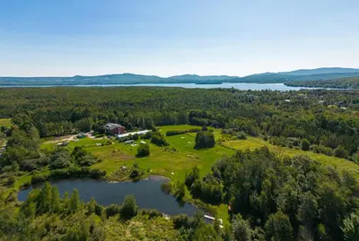 an aerial view of a farm and a lake at Villa de Brome in Lac-Brome