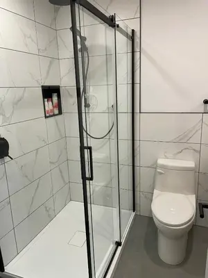 a bathroom with a toilet and a glass shower at Bromont Lodge 871 Shefford suite 205 in Bromont
