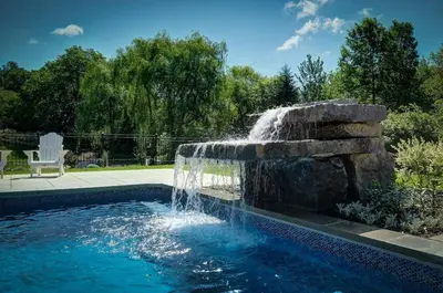 a swimming pool with a fountain in a yard at Bromont Lodge 871 Shefford suite 205 in Bromont
