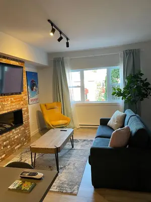a living room with a blue couch and a fireplace at Bromont Lodge 871 Shefford suite 205 in Bromont
