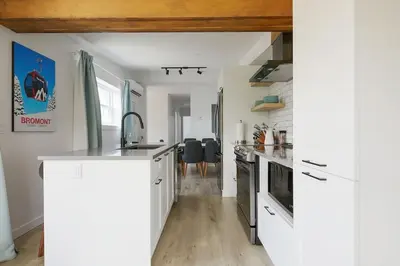 a kitchen with white cabinets and a counter top at Bromont Lodge 837 shefford suite 200 in Bromont