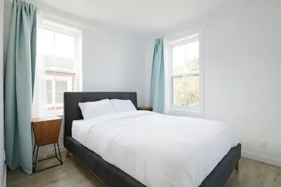 a bedroom with a white bed and two windows at Bromont Lodge 837 shefford suite 200 in Bromont