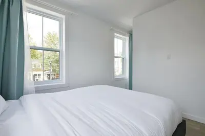 a white bed in a room with two windows at Bromont Lodge 837 shefford suite 200 in Bromont