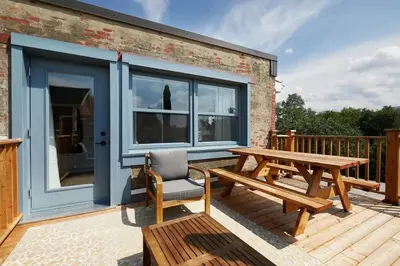 a wooden deck with a picnic table and a bench at Bromont Lodge 837 shefford suite 200 in Bromont