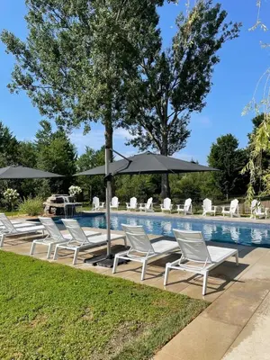 a group of chairs and umbrellas next to a pool at Bromont Lodge 837 shefford suite 200 in Bromont