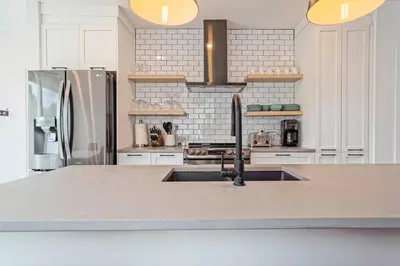 a kitchen with a sink and a stainless steel refrigerator at condo 3 chambres vue sur la montagne 837-202 in Bromont