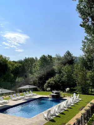 a pool with white chairs and a group ofitures at condo 3 chambres vue sur la montagne 837-202 in Bromont