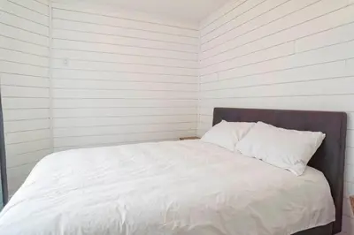 a bed with white sheets and pillows in a room at condo 3 chambres vue sur la montagne 837-202 in Bromont