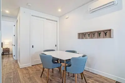 a dining room with a white table and blue chairs at 201 Condo au rez de chaussée , au coeur de Bromont in Bromont