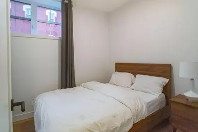 a bedroom with a white bed with a window at 883 suite 102 Bromont Vieux Village 2cac , foyer in Bromont