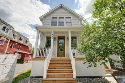 a white house with a front porch and stairs at 883 suite 102 Bromont Vieux Village 2cac , foyer in Bromont