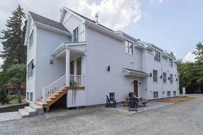 a white building with a porch and a patio at 883 suite 102 Bromont Vieux Village 2cac , foyer in Bromont