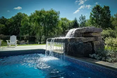 a swimming pool with a fountain in a yard at 871 shefford suite 207 3chambres in Bromont