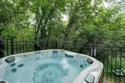 a jacuzzi tub on a balcony with trees at 871 shefford suite 207 3chambres in Bromont