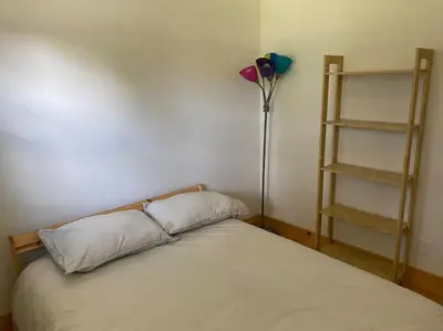 a bedroom with a bed and a floor lamp at Magnifique centenaire rénovée, air climatisé, arcade, 3 chambres fermées in Austin