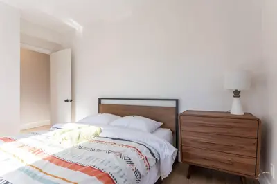 a bedroom with a bed and a wooden dresser at Free Parking, Beautiful 4 1/2-2 BR apartment in Montréal