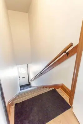 a stairway with a black rug and a metal railing at Free Parking, Beautiful 4 1/2-2 BR apartment in Montréal
