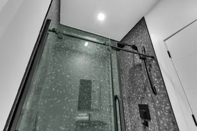 a shower with a glass door and a mirror at Deluxe Suites Downtown Montreal in Montréal