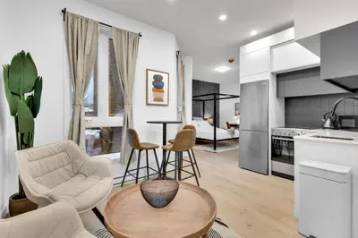 a kitchen and living room with a table and chairs at Deluxe Suites Downtown Montreal in Montréal