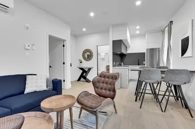 a living room with a blue couch and a kitchen at Deluxe Suites Downtown Montreal in Montréal