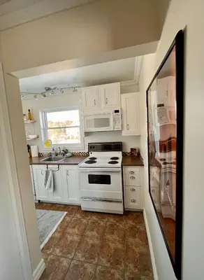 a white kitchen with a stove and a window at Chaleureux condo à Magog in Magog-Orford