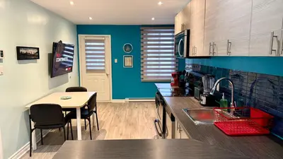 a kitchen with a sink and a table with chairs at A&I Cosy&Bright Apartments near Old Port and South Shore in Longueuil