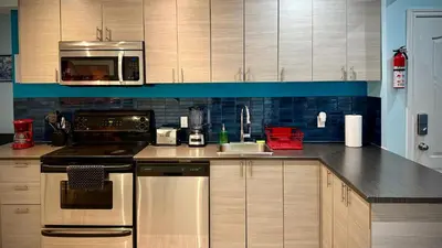 a kitchen with a stove and a sink and a microwave at A&I Cosy&Bright Apartments near Old Port and South Shore in Longueuil