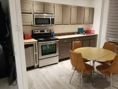 a kitchen with a wooden table and a table and chairs at A&I Cosy&Bright Apartments near Old Port and South Shore in Longueuil