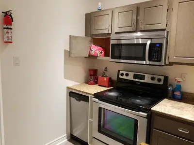a kitchen with a stove and a microwave at A&I Cosy&Bright Apartments near Old Port and South Shore in Longueuil