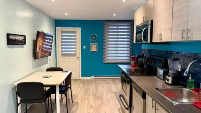 a kitchen with blue walls and a table and chairs at A&I Cosy&Bright Apartments near Old Port and South Shore in Longueuil