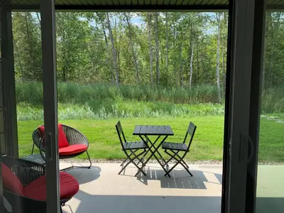 a view of a patio with a table and chairs at Le Memph Colibri condo cottage eco responsible - hot tub & pool Memphrémagog Lake in Magog-Orford
