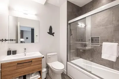 a bathroom with a shower and a toilet and a sink at Le Memph Colibri condo cottage eco responsible - hot tub & pool Memphrémagog Lake in Magog-Orford