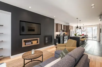 a living room with a couch and a table at Le Memph Colibri condo cottage eco responsible - hot tub & pool Memphrémagog Lake in Magog-Orford
