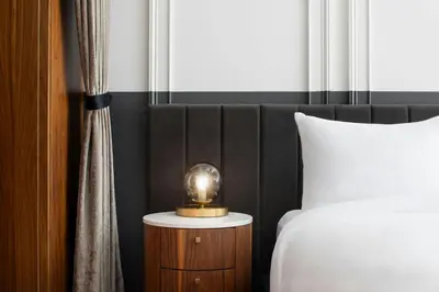 a bedroom with a bed and a clock on a night stand at HONEYROSE Hotel, Montreal, a Tribute Portfolio Hotel in Montréal