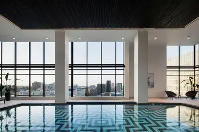 a swimming pool in a building with large windows at HONEYROSE Hotel, Montreal, a Tribute Portfolio Hotel in Montréal