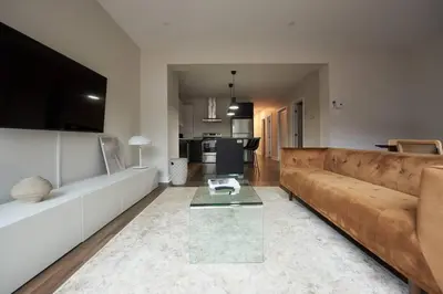 a living room with a couch and a table at Design 3 bedroom flat with private terrace in Little Italy by Denstays in Montréal
