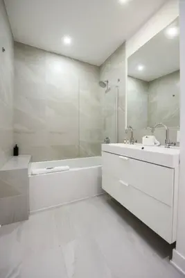 a white bathroom with a tub and a sink at Design 3 bedroom flat with private terrace in Little Italy by Denstays in Montréal