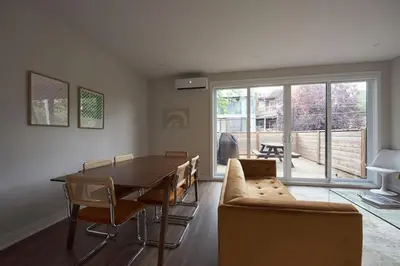 a living room with a dining room table and a couch at Design 3 bedroom flat with private terrace in Little Italy by Denstays in Montréal