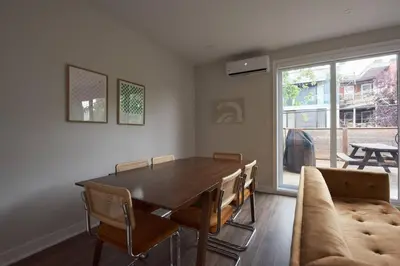 a dining room with a table and chairs and a couch at Design 3 bedroom flat with private terrace in Little Italy by Denstays in Montréal