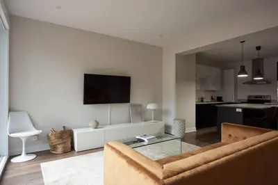 a living room with a couch and a table at Design 3 bedroom flat with private terrace in Little Italy by Denstays in Montréal