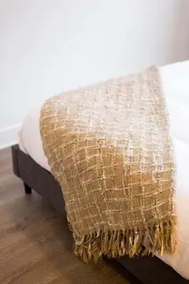 a bed with a blanket on top of it at Brand New Light filled Mile End Flat by Denstays in Montréal