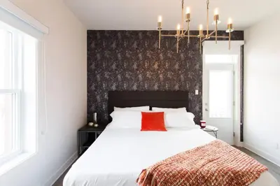 a bedroom with a large white bed with a red pillow at Brand New Light filled Mile End Flat by Denstays in Montréal