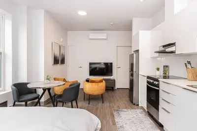 a kitchen and living room with a table and chairs at Amazing New Apartment Close to Mount Royal Le Plateau by Denstays in Montréal
