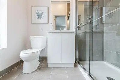 a white bathroom with a toilet and a shower at Amazing New Apartment Close to Mount Royal Le Plateau by Denstays in Montréal