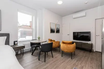 a bedroom with a bed and a table and chairs at Amazing New Apartment Close to Mount Royal Le Plateau by Denstays in Montréal