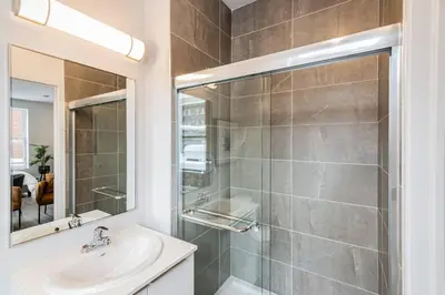 a bathroom with a shower and a sink and a mirror at Amazing New Apartment Close to Mount Royal Le Plateau by Denstays in Montréal