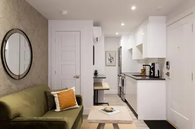 a living room with a green couch and a table at Palms Little Italy Studio with full bathroom by Denstays in Montréal