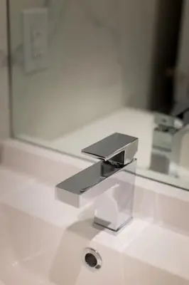 a bathroom sink with a silver faucet and a mirror at Palms Little Italy Studio with full bathroom by Denstays in Montréal