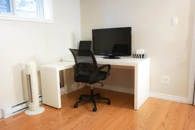 a computer desk with a monitor and a chair at Free Parking - Great 1BR near Henri Bourassa Metro in Montréal
