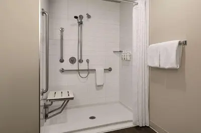 a bathroom with a shower with a tub and a sink at Microtel Inn & Suites by Wyndham Boisbriand in Sainte-Thérèse-de-Blainville